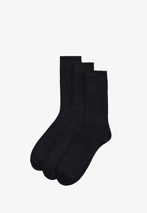 Tres pares de calcetines negros hechos de una mezcla de algodón. Presentan una textura suave, puños acanalados y un diseño clásico de longitud media.