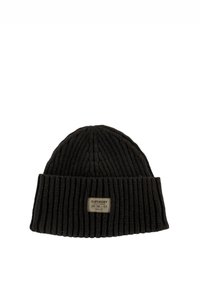 Gorro de punto acanalado negro con dobladillo y una etiqueta tejida rectangular que muestra el nombre de la marca y detalles de cuidado.
