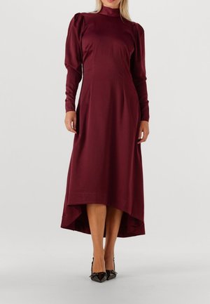 Burgundy klänning med långa puffärmar, hög hals och asymmetrisk fåll. Tillverkad av ett smidigt tyg; har en skräddarsydd silhuett.
