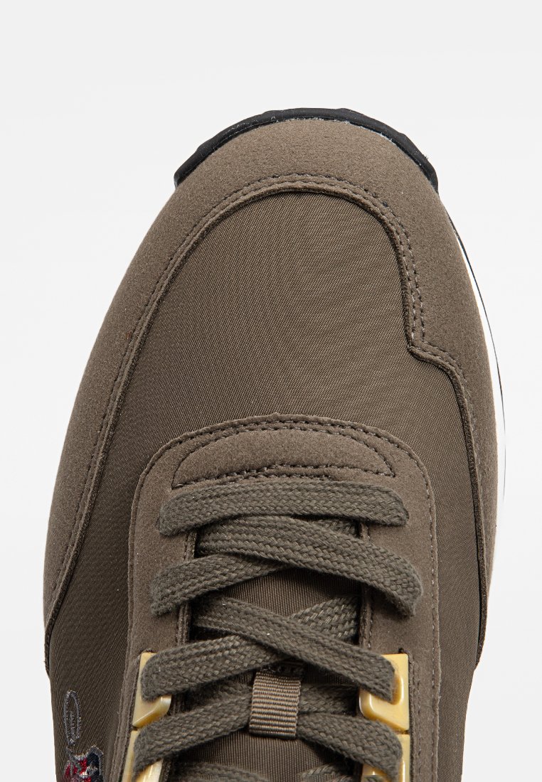 Zielonooliwkowe sneakersy z teksturowanej tkaniny, z sznurówką, złotymi oczkami i czarną gumową podeszwą. Posiadają minimalne detale brandowe.