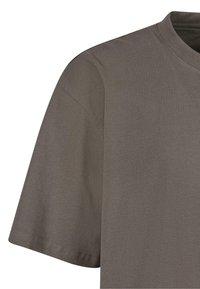 T-shirt en coton gris à manches courtes, col rond et texture lisse. Présente des coutures discrètes et aucun motif ou accent visible.