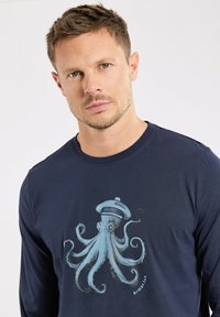 Granatowa koszulka z długim rękawem z bawełny, z grafiką jasnoniebieskiego ośmiornicy w kapeluszu marynarskim z przodu.