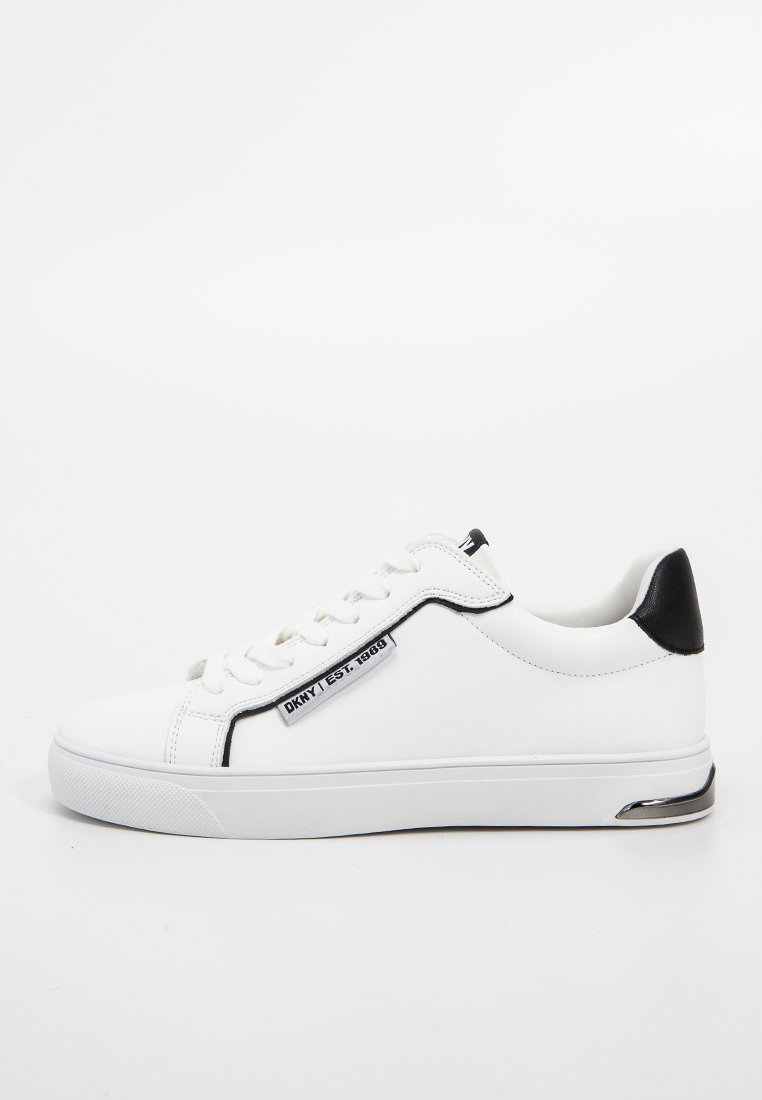 Witte sneaker met zwarte hielaccent. Gemaakt van soepel leer, met een vetersluiting aan de voorkant, een gewatteerde kraag en een logotag aan de zijkant.