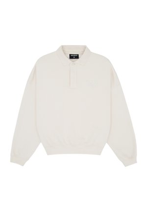 Off-white long-sleeve polo shirt with elastic waistband, collar, button placket, and subtle "WRSTBHVR" branding on the chest and collar label.