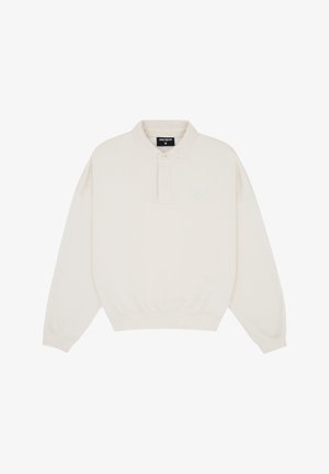 Off-white long-sleeve polo shirt with elastic waistband, collar, button placket, and subtle "WRSTBHVR" branding on the chest and collar label.