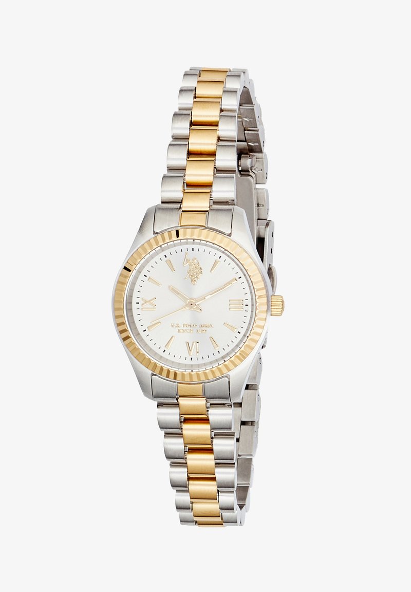 Montre-bracelet en métal bicolore argent et or avec cadran blanc, chiffres romains dorés aux positions 3, 6, 9 et logo à 12 heures.