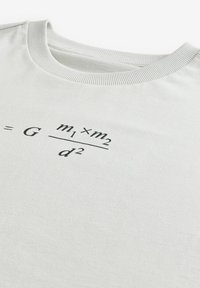 Világosszürke pamut póló kerek nyakkal, a mellkason középre helyezett fekete nyomott formulával. Puha tapintású, laza fazonú.