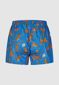 Men’s swim shorts in blue fabric featuring an all-over print of orange tigers and green foliage. Elastic waistband for comfort.
