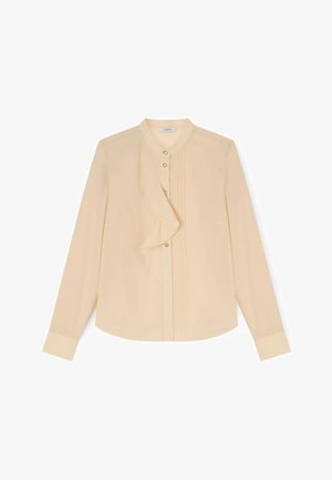 Beige blouse met lange mouwen en ruches langs de knoopsluiting, voorzien van kleine gouden knopen, een ronde halslijn en mouwen met manchetten.