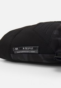 Black waterproof fabric pouch with soft texture, featuring a label that reads "R-TEX®XT" and subtle camouflage pattern.