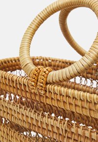 Flettet stråkurv med runde håndtag, der har en naturlig beige farve, tekstureret overflade og detaljeret fletningsmønster.