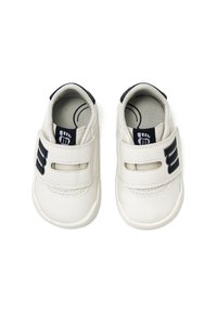 Zapatos de cuero blanco con puntera redonda y doble tira de velcro; presentan un logo negro en el costado y una textura simple y suave.