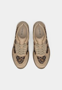 Μπεζ και καφέ αθλητικά παπούτσια με λεοπάρ σχέδιο και κορδόνια, φωτογραφημένα από πάνω, που δείχνουν το όνομα της μάρκας «Gabor» μέσα σε κάθε παπούτσι.
