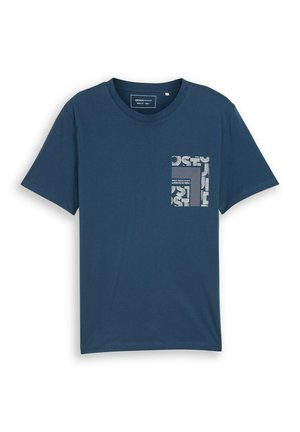 Tumši zils īsām piedurknēm T-krekls ar apaļu izgriezumu un kvadrātveida baltu ģeometrisku rakstu kreisā krūšu kabatas rajonā.