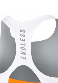 White sports bra with racerback design, perforated detail, and the word "ENDLESS" printed vertically on the back panel.