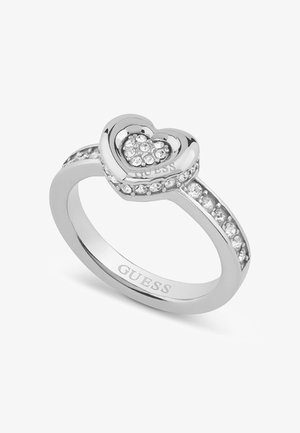 Silberring mit Herzdesign, verziert mit kleinen klaren Steinen, graviert mit "GUESS" und akzentuiert durch eine Reihe von Steinen am Band.