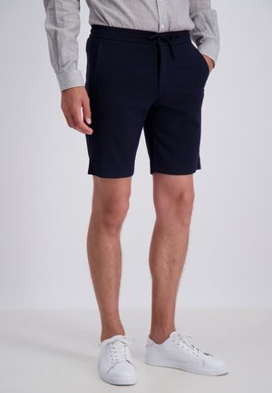 Shorts bleu marine en tissu doux et extensible, avec une taille élastique et un cordon de serrage, dotés de poches latérales et d'un design ajusté.