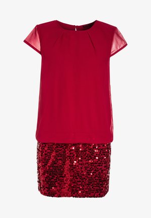 Rode top met korte mouwen en een geplooid ontwerp, gecombineerd met een glinsterende paillettenrok. De outfit is geschikt voor feestelijke gelegenheden.