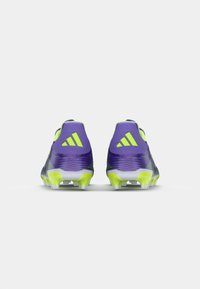Paarse en neon groene voetbalschoenen met een gestructureerd oppervlak, hielaccenten en een gestroomlijnd ontwerp; voorzien van witte noppen voor grip.