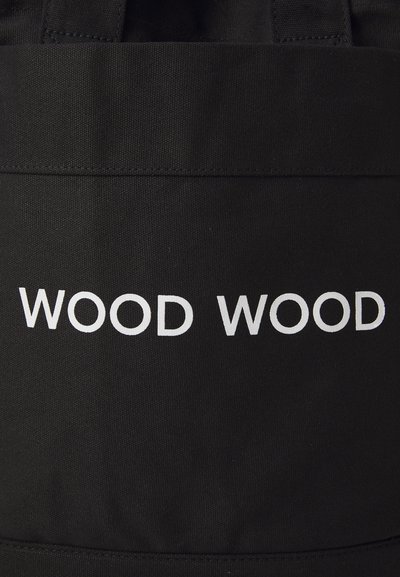 Must mustra kott, mis on valmistatud vastupidavast kangast ja millel on julge valge tekst "WOOD WOOD." Lihtne disain koos tugeva õlarihmaga.