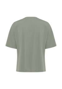 Tričko s krátkým rukávem a kulatým výstřihem vyrobené z jemné, světle zelené tkaniny. Má volný střih, hladkou strukturu a minimalistický design bez viditelných log.