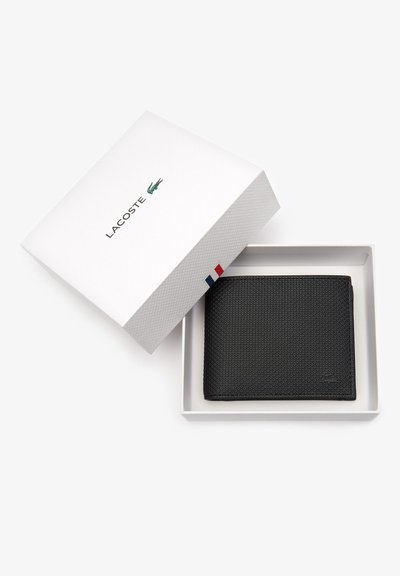 Portefeuille noir en matériau texturé, avec un design plié et un logo discret, placé dans une boîte cadeau blanche avec un couvercle.