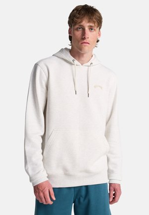 Hoodie gris clair en matériau doux, avec une poche frontale et des cordons, arborant un petit logo de marque en broderie dorée.