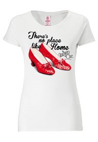 White t-shirt featuring red sequin shoes and text "There's no place like Home" with "The Wizard of Oz" logo. Short sleeves, round neckline.