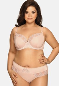 Completo reggiseno e slip di color rosa chiaro con dettagli in pizzo, texture liscia, supporto con ferretto e motivo floreale. Spalline regolabili e dettaglio con fiocco.