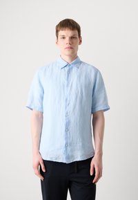 Light blue short-sleeve shirt with a button-down collar, made of textured fabric, featuring visible seams and a relaxed fit.