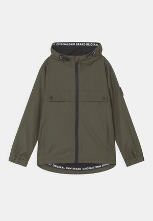 Veste à capuche verte avec fermeture éclair à l'avant, poches à rabat, poignets élastiques et texte "Original DNM Brand" visible à l'intérieur de la capuche et de l'ourlet.