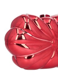 Červená kovová psaníčko s zakřiveným květinovým vzorem. Má hladkou texturu a lesklý povrch. Zavírání v horní části pro bezpečné upevnění.