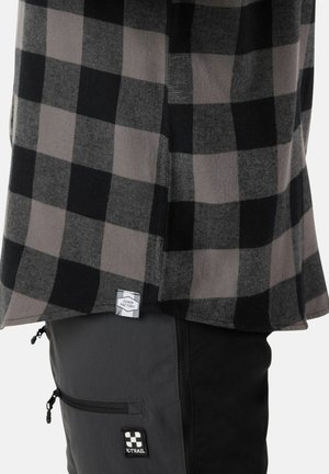 Gray and black plaid shirt paired with black cargo pants. Shirt features a curved hem and tag; pants include a zip pocket and logo.