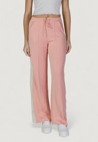 Pantaloni della tuta rosa con vestibilità comoda, caratterizzati da bottoni laterali e pannelli bianchi a contrasto. Realizzati in tessuto morbido, con tasche frontali e vita con cordoncino.