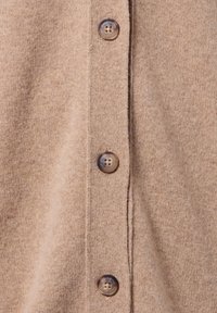Brauner Cardigan aus weichem Strickstoff mit vier runden, beigen Knöpfen entlang der Vorderleiste und einer strukturierten Oberfläche.