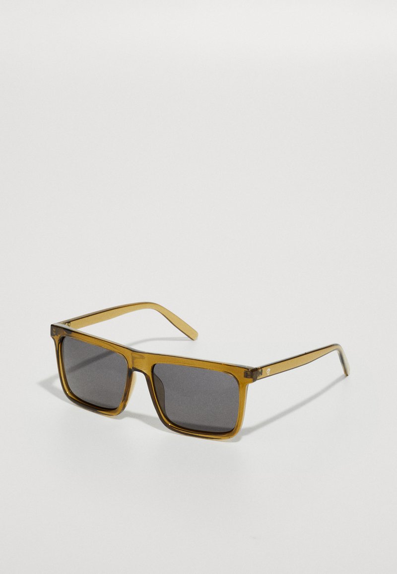 Ochelari de soare rectangulare cu o ramă transparentă de culoare chihlimbar, lentile gri închis și brațe subțiri. Prezintă un logo subtil pe lateral.
