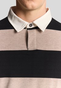 Gestreiftes Poloshirt in Schwarz, Beige und Creme; aus Baumwolle; klassischer Kragen mit Knopfverschluss; glatte Textur.