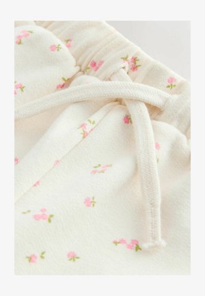 Jasnokremowa tkanina z małymi, różowymi wzorami kwiatowymi i zielonymi łodygami, posiadająca talię ze ściągaczem i miękką fakturę.