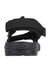 Musta sandaali, jossa on leveä säädettävä kangashihna, pehmustettu pohja ja teksturoitu kumipohja. Takaviisto näyttää muotoilun ja materiaalin yksityiskohdat.