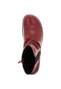 Bottine en cuir rouge à bout arrondi, avec un dessus froncé doux et une fermeture éclair sur le côté. Texture lisse et doublure intérieure noire.