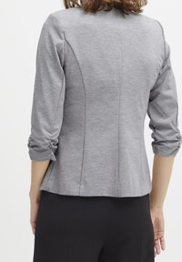 Gråt skräddarsydd jacka med trekvartsärmar, texturerad tyg och sömnad detalj bak, matchad med svarta byxor.