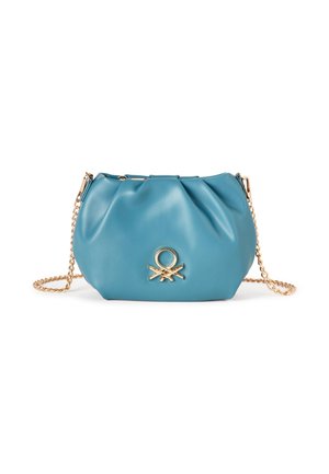 Pequeño bolso de hombro de cuero azul suave con parte superior fruncida y correa de cadena dorada, con un emblema circular dorado en la parte delantera.