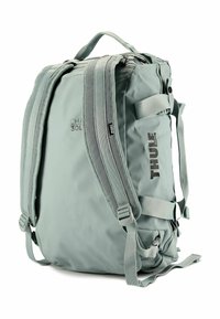 Mochila Thule de 30L en verde claro, fabricada con tejido duradero. Cuenta con correas de hombro acolchadas, asa superior y compartimentos con cremallera.