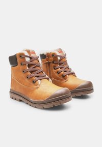 Pruunid nahast talvesaalikud, millel on karvane vooder, paksud kummist tallad, lukkudega esiosad ja külgkokkutõmbed, paigutatud valgele taustale.