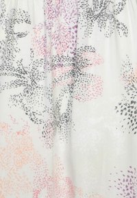 Tissu blanc avec un motif floral en rose, violet et noir, doté d'un design texturé. Les fleurs présentent des formes et des contours variés.