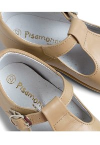 Pantofi din piele maro cu un design Mary Jane, având o deschidere lângă degetul mare, o curea ajustabilă și o talpă interioară texturată cu branding.