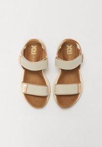 Beige sandaler med to brede stropper, brun polstret såle og subtile gulllogo detaljer; lett og åpen tann design.