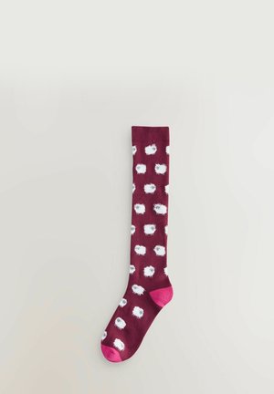 Knähöga bordeauxfärgade strumpor med ett plyschigt vitt fårmönster och rosa detaljer på tån och hälen. Slät textur, elastisk manschettdesign.