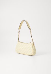 Kohollettu keltainen käsilaukku, joka on valmistettu teksturoidusta materiaalista ja jossa on ketjuun ripustettu olkahihna, ylhäällä vetoketju ja logotunnus.