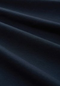 Teren de stof de culoare bleumarin închis, cu o suprafață netedă și texturată, având nervuri subtile și pliuri ondulate, creând profunzime în aspect.